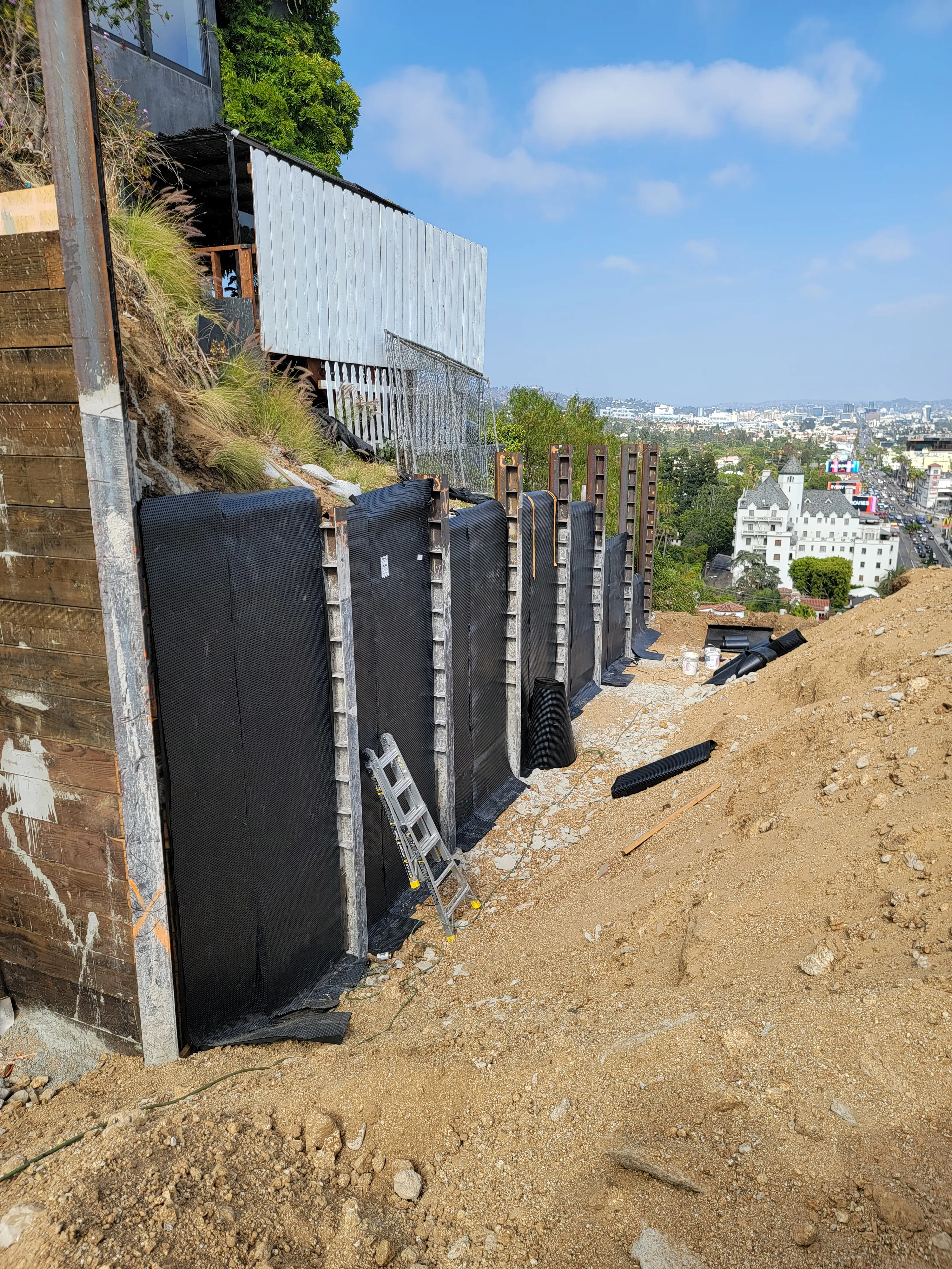 Exterior waterproofing membrane being applied to a below-grade concrete foundation wall.